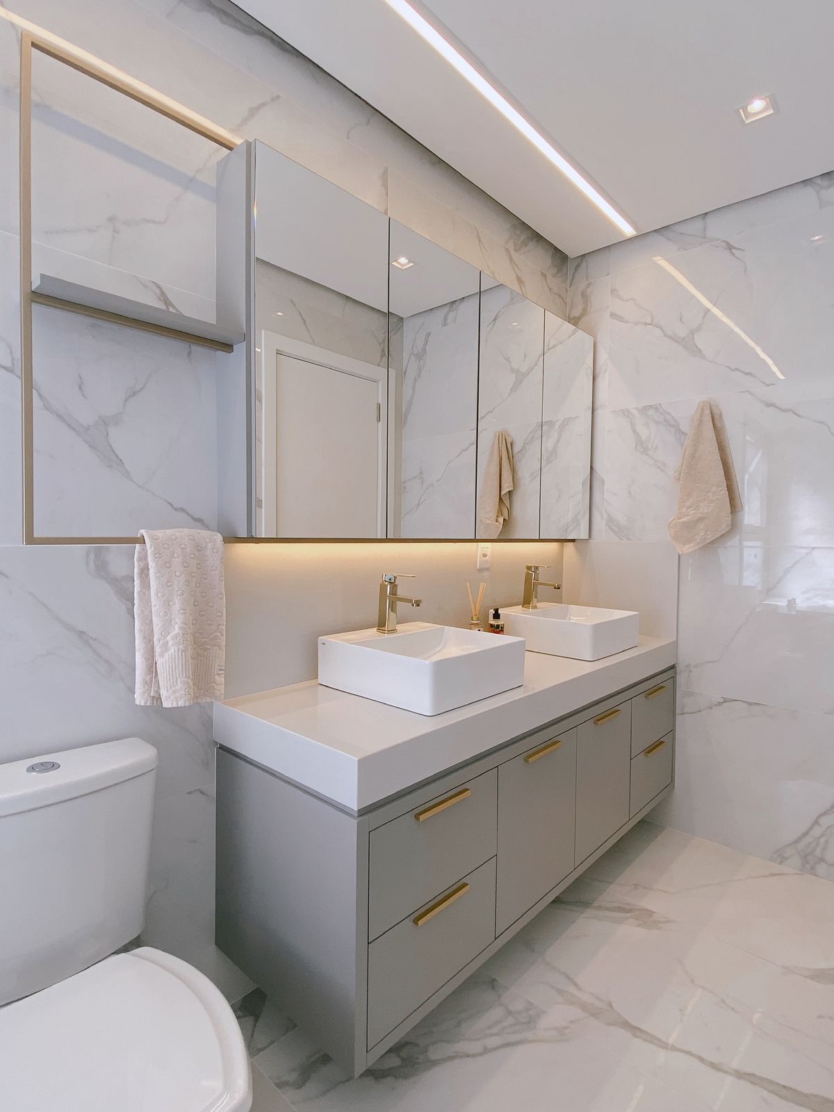 Elegante banheiro master planejado em Alphaville com bancada dupla, iluminação suave e revestimentos que remetem a um spa de luxo.